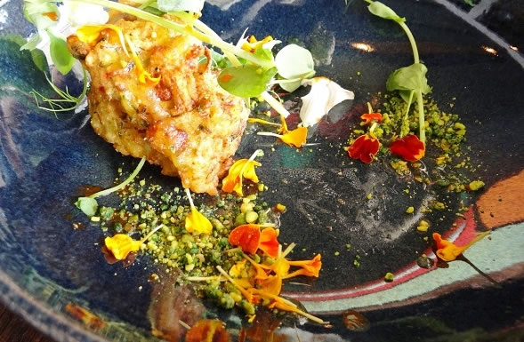 The Zucchini Fritters with edible flowers and crushed pistachios