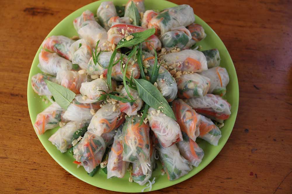 Rice paper rolls stacked on a green plate