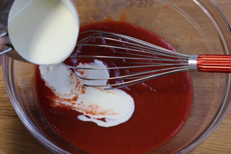Adding cream to tomato puree for butter chicken