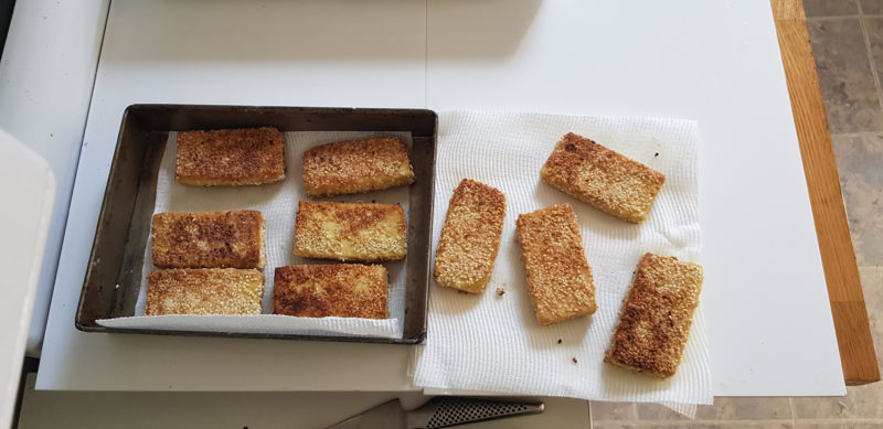 Slices of fried tofu draining in a tray