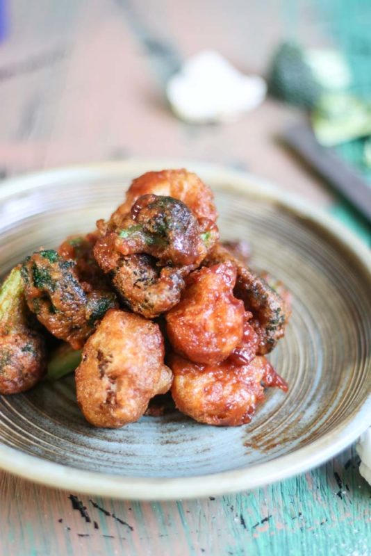 A plate of broccoli and cauliflower wings in spicy sauce