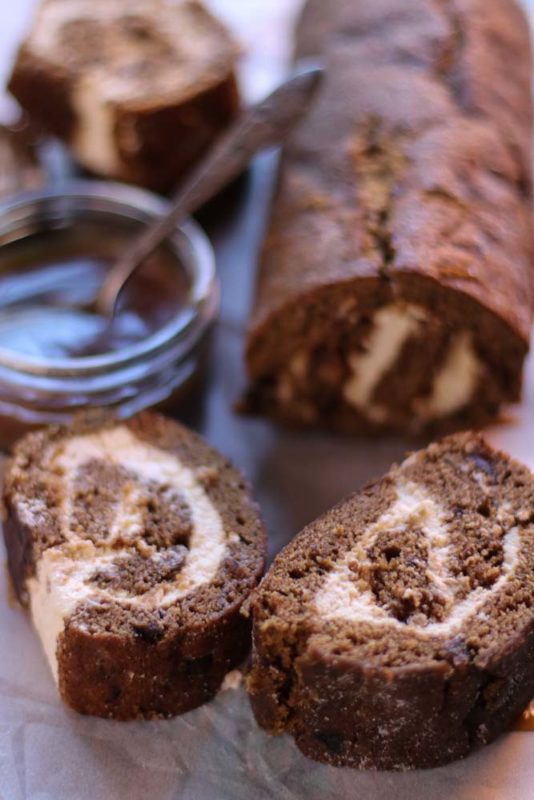 A date swiss roll cut into sections on a plate